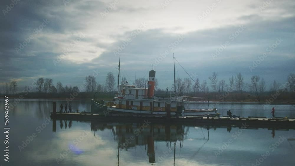 A boat stationed by the shore on a cloudy day A boat stationed by the shore on a cloudy day