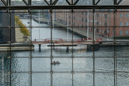 Interior view at Det Kgl. Bibliotek, the Black Diamond Royal Danish Library and background of canal and Cirkelbroen through glass facade. 