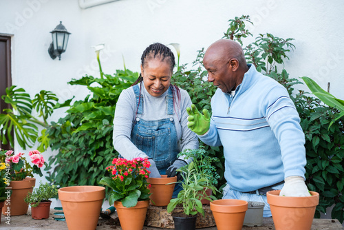 Senior man and woman doing gardening together outdoors so that the plants bloom in season. Concept: Gardening, crafts, flowers