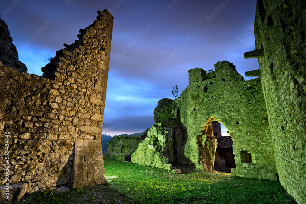 The portal of the mysterious medieval walls of Corno castle at night. Lenzima, Isera, Vallagarina, Trentino, Italy.