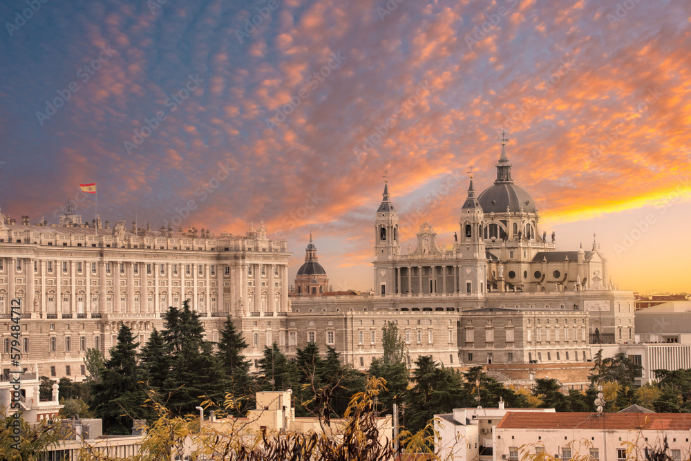 Madrid skyline with Santa Maria la Real de La Almudena Cathedral and the Royal Palace during sunset.
