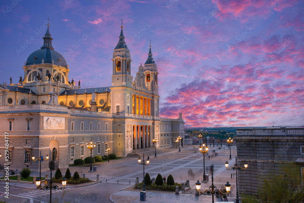 Madrid skyline with Santa Maria la Real de La Almudena Cathedral and the Royal Palace during sunset.

