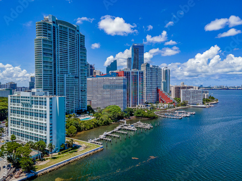 Modern buildings overlooking the Miami South Channel in Miami Beach Florida. Spectacular city skyline with boats docked at the bay against blue sky and clouds.