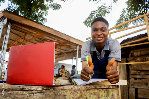 young african carpenter standing holding working calling laptop