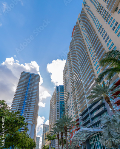 Looking up at exterior of apartments and cloudy blue sky in Miami Beach Florida. View from the ground of modern residential buildings in the city on a beautiful sunny day. © Jason