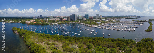 Panorama of boats against Miami Florida skyline with blue sky and clouds. Scenic view of high rise condomimiums and buildings overlooking the manmade inland channel.