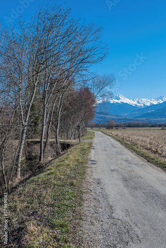 Chemin dans la campagne en Isère, vue sur les montagnes enneigées