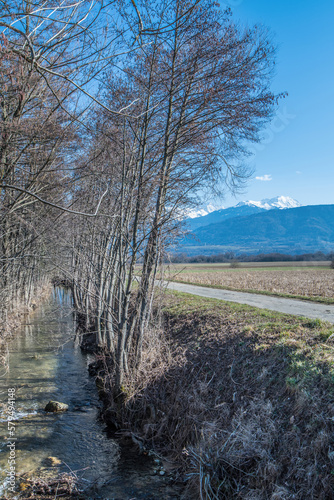 Chemin dans la campagne en Isère, vue sur les montagnes enneigées