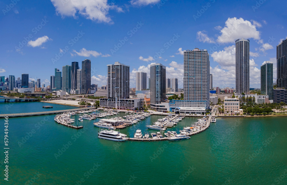 Fototapeta premium Boats at Sea Isle Marina and Intracoastal Waterway in Miami Beach Florida. Scenic aerial view of moored boats against buildings in city skyline and bright blue sky.
