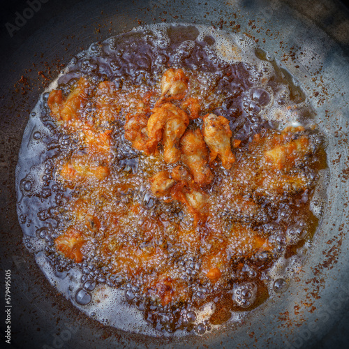 Deep fried chicken wings in wok pan