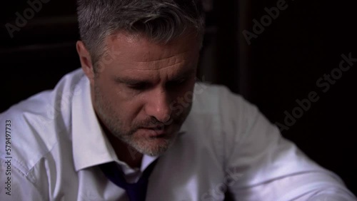 Close-up portrait of a businessman man in a white shirt with an untied tie, drinks alcohol, whiskey, scotch, sighs, received a false accusation, sad, upset, exhausted