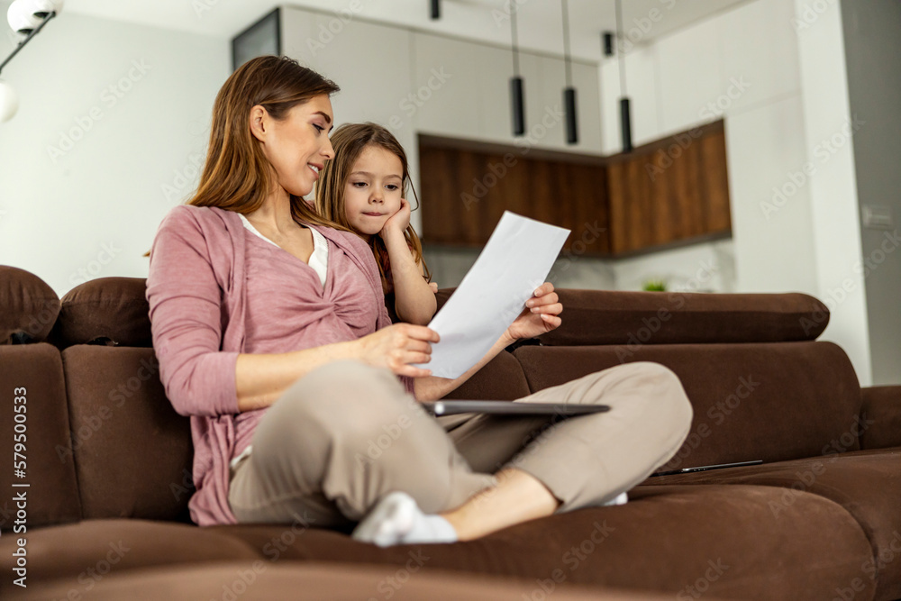 Mother and daughter doing homework from school together at home Mother and daughter doing homework from school together at home
