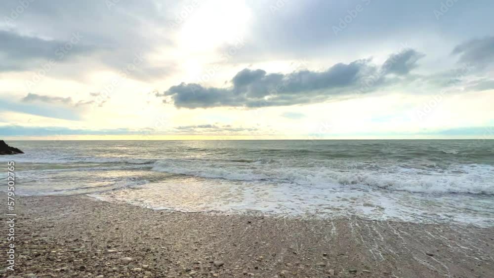 Powerful sea waves are crashing on the Black Sea coast. Waves splash on the beach with pebbles during a storm. Storm at sea. Panoramic view of the Black Sea. Russia. Sunset on the beach. 4K Powerful sea waves are crashing on the Black Sea coast. Waves splash on the beach with pebbles during a storm. Storm at sea. Panoramic view of the Black Sea. Russia. Sunset on the beach. 4K