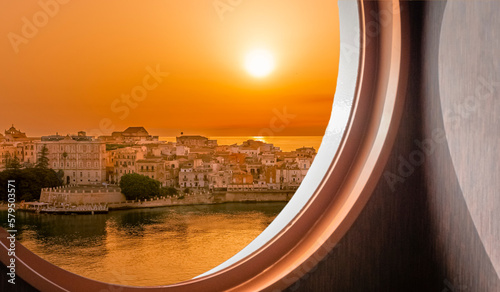 Fotografie Vue de la ville de Syracuse au lever du soleil depuis le hublot d'un navire de croisière en navigation