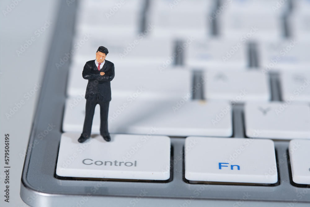 Businessman, boss stands thinking on a keyboard. Concept: business plan Businessman, boss stands thinking on a keyboard. Concept: business plan