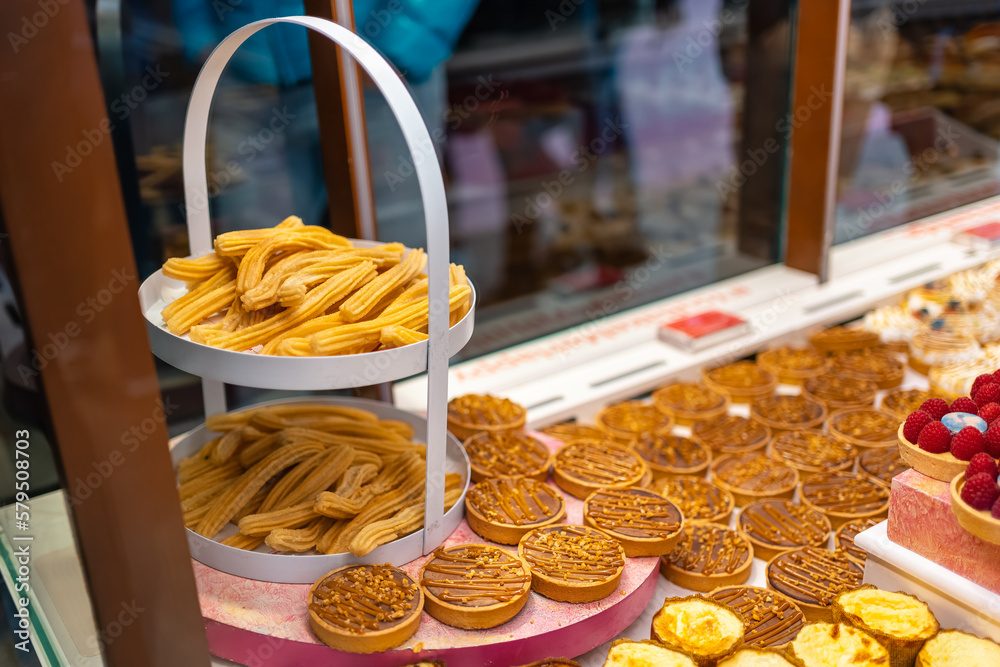 Fototapeta premium Showcase with various products for breakfast and typical churros from Madrid, Mercado de San Miguel.