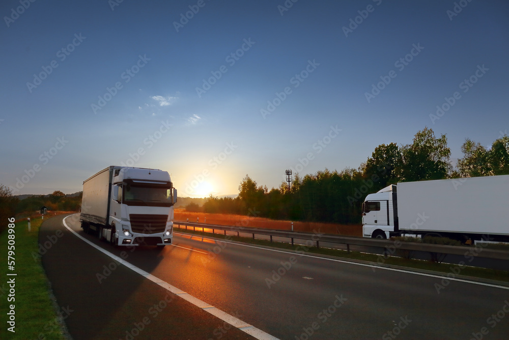 Truck transport on the road at sunset and cargo 