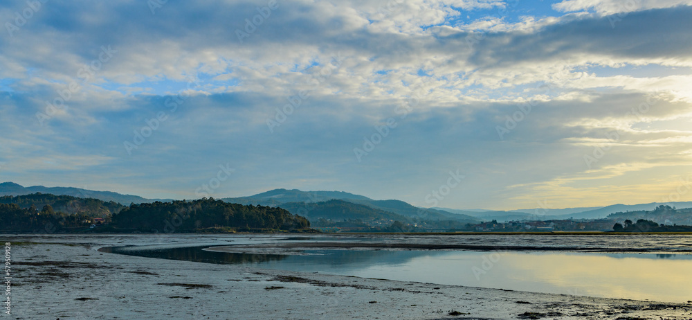 panorama of marshes with forests and mountains in the background at sunset