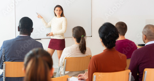 Beautiful young european woman at university in front of chalkboard