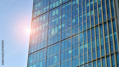 Looking up at the commercial buildings in downtown. Modern office building against blue sky. Windows of a modern glass building.