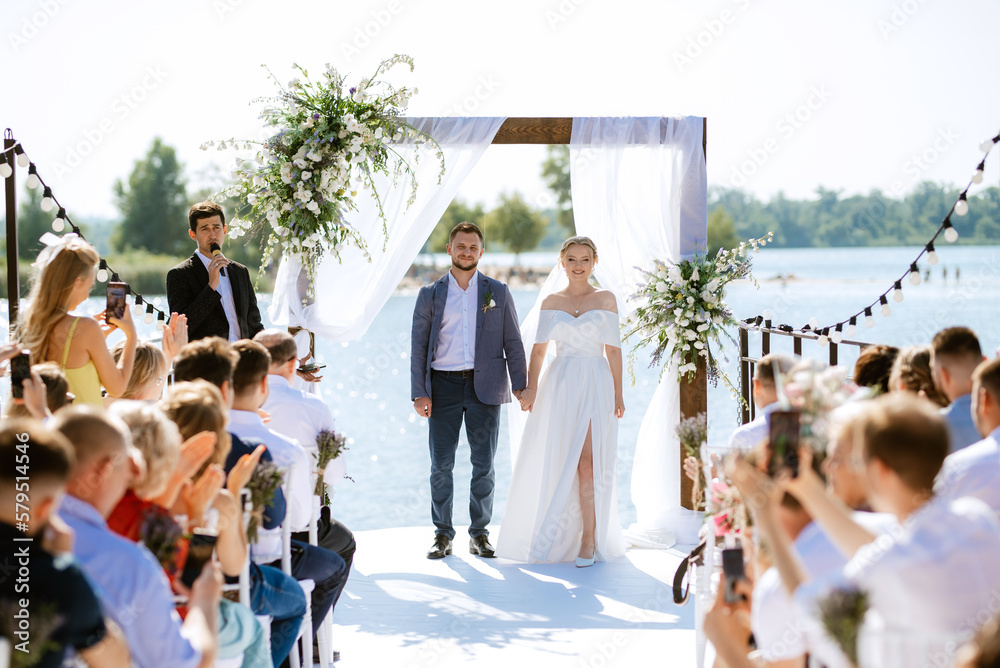 Fototapeta premium wedding ceremony on a high pier near the river