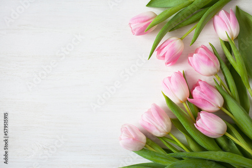 Fototapeta Naklejka Na Ścianę i Meble -  Pink flowers tulips on a white wooden background, copy space, congratulations