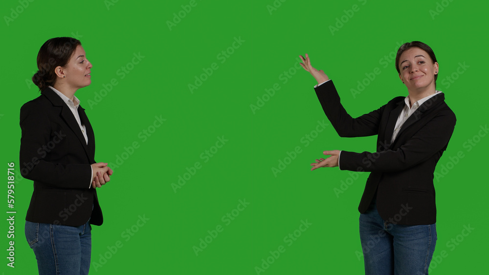 Professional manager pointing aside to show advertisement over greenscreen studio backdrop, creating example ad on blank copyspace. Young adult with suit showing ad icon in front of camera. Professional manager pointing aside to show advertisement over greenscreen studio backdrop, creating example ad on blank copyspace. Young adult with suit showing ad icon in front of camera.