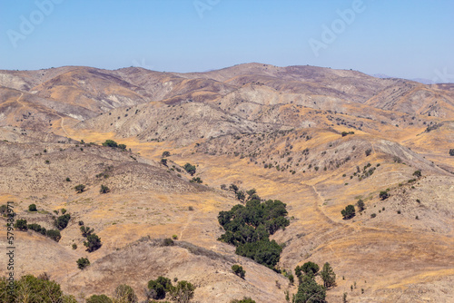Dry grassy hills and large oak trees during the summer months in Calabasas, California.
