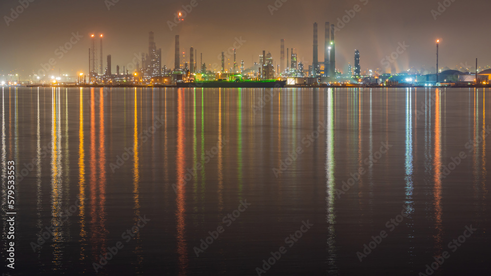 Oil refinery at night. Oil refinery lights reflecting to sea. Night cityscape Long exposure photography