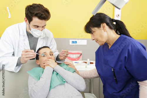 scared woman covering her mouth with her hands at dentist