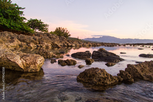 Sunset and golden hour at Sharks Cove or Pupukea Beach Park, on the North Shore of Oahu, Hawaii. Calm waters and rocky beach.