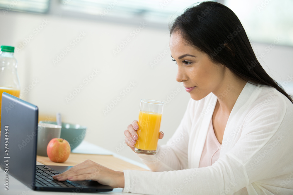 smiling woman writing in notebook at home at the table smiling woman writing in notebook at home at the table