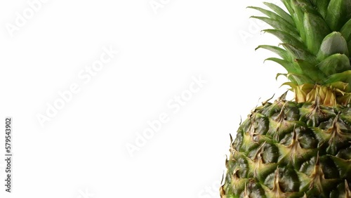 A delicious pineapple rotating on the right side against isolated a white background.