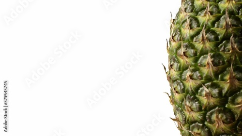 Pineapple fruit rotating on the right side against a isolated white background.