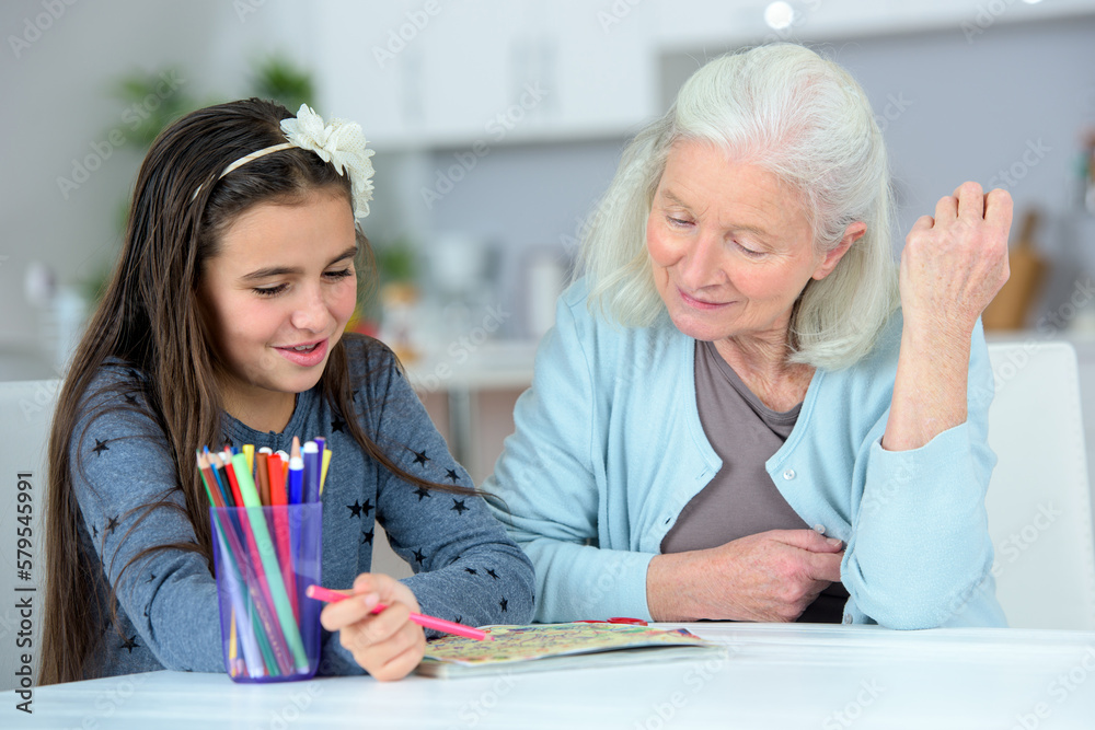 granny helping her granddaughter with her homework granny helping her granddaughter with her homework