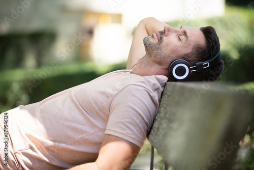 man relaxes on a bench in the park