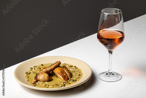 Delicious chicken in sauce, accompanied by a glass of wine.