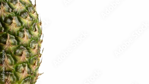 Pineapple fruit rotating on the left side against a isolated white background.
