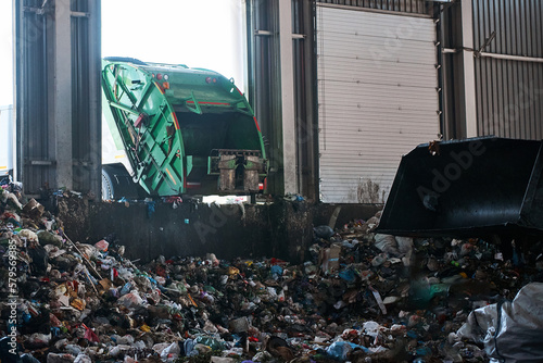 фотографія A garbage truck unloads household waste in the receiving chamber of a waste sort