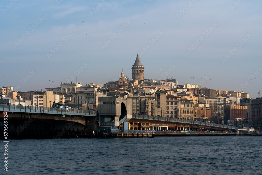 Beyoglu district with Galata Tower and Galata Bridge in the foreground from the waters of the Golden Horn Bay on a sunny day, Istanbul, Turkey