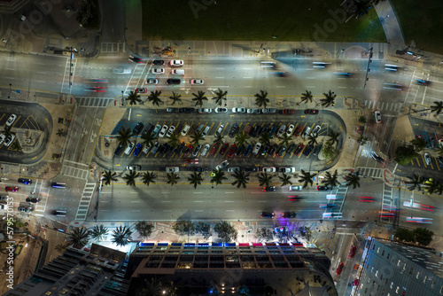 Aerial view of brightly illuminated street in downtown district of Miami city in Florida, USA. Traffic in modern american midtown