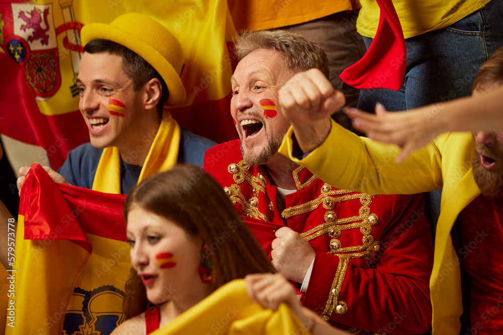 Fototapeta premium Live game. People, football, soccer fans emotionally watching match, cheering up favourite team. Fans wearing colorful scarves and flags. Concept of sport, cup, world, team, event, competition