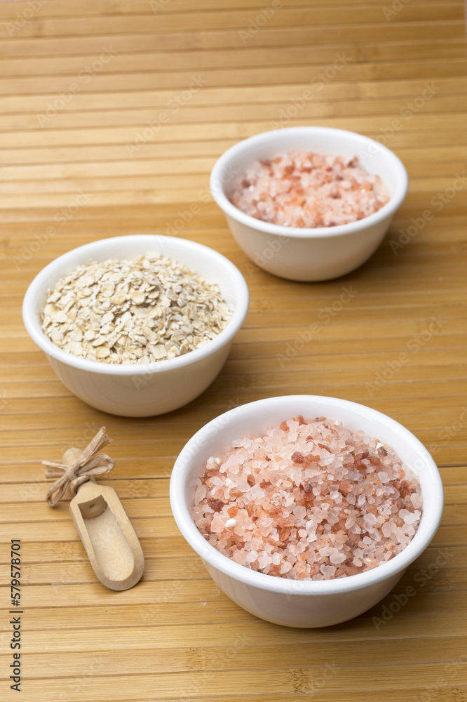 White bowls filled with coarse Himalayan salt and oats. White bowls filled with coarse Himalayan salt and oats.