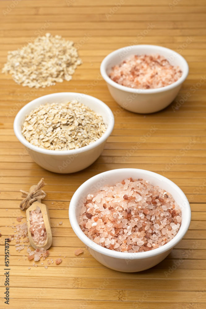 White bowls with coarse Himalayan salt and oats. White bowls with coarse Himalayan salt and oats.
