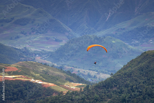 Parachute jumpers perform during the Paragliding festival. The annual paragliding festival is held in Mu Cang Chai, Vietnam