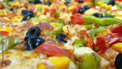 Delicious vegetable pizza with a lot of cheese, olives and other toppings