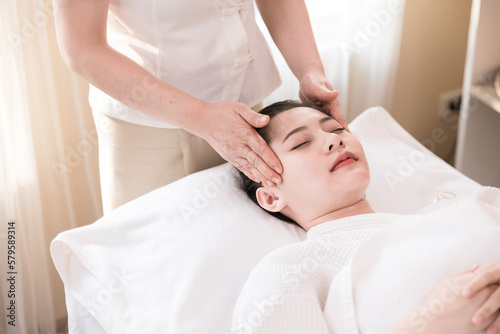 Young Asian woman getting spa massage treatment at beauty spa salon. Face massage, Relaxing massage, Spa skin and body care