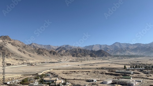 Leh airport with its runway and buildings with mountain range and blue clear sky