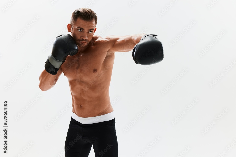 Man athletic bodybuilder poses in boxing gloves with nude torso abs in full-length background, boxing and martial arts. Advertising, sports, active lifestyle, competition, challenge concept. 