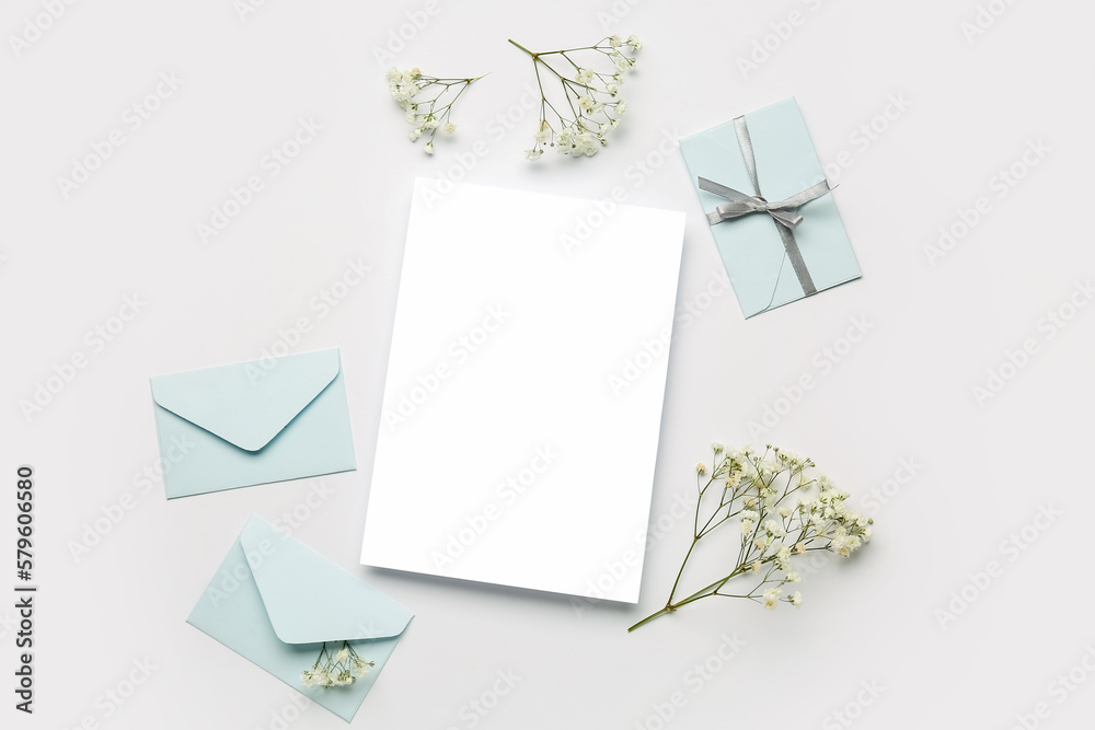 Composition with blank card, envelopes and gypsophila flowers on white background Composition with blank card, envelopes and gypsophila flowers on white background